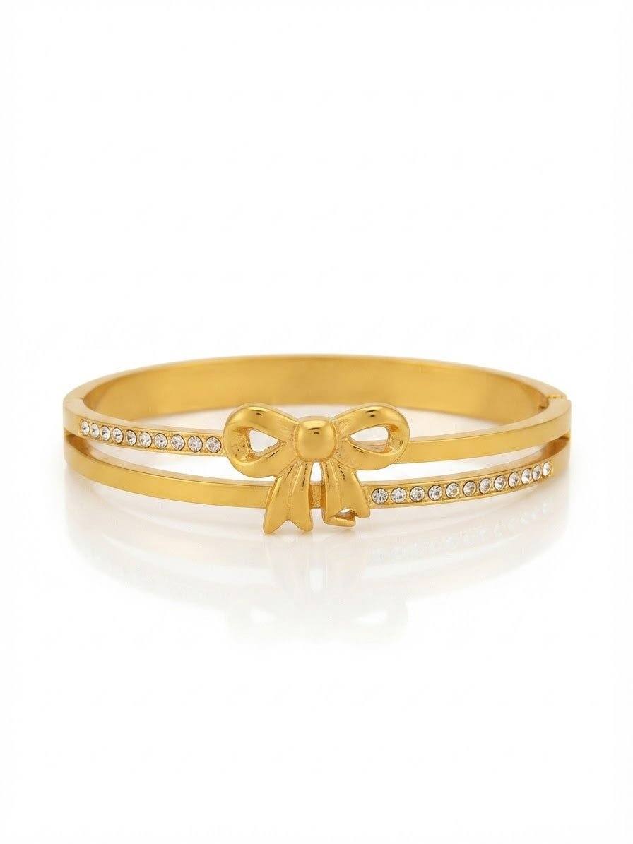 Gold bangle with bow centerpiece and sparkling crystal accents